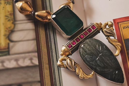 Decorative bookend with gold and black handcrafted silver jewelry on an open book